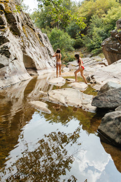 istock People Enjoying a Rocky Stream in a Lush Natural Setting 2198426209