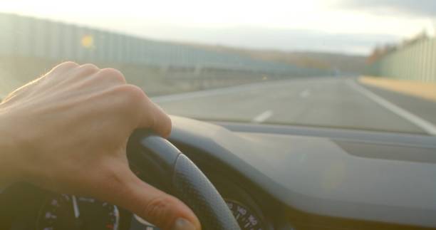 istock Driving along an open road where the steering wheel is in clear focus 2198430311