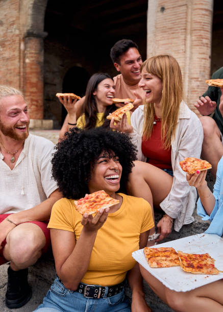 istock Happy multi-ethnic friends eating pizza outdoors in urban setting 2198430993