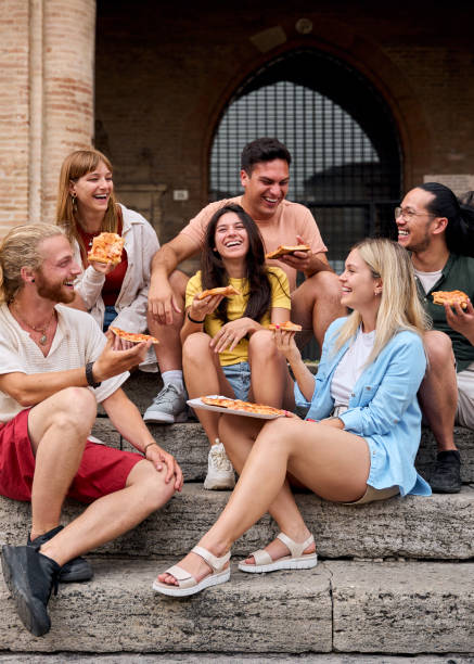 istock Happy friends eating pizza outdoors on ancient steps 2198431044