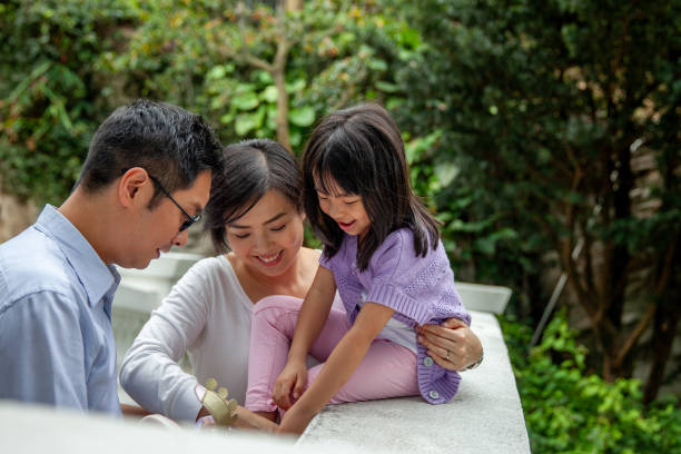 A father helps his daughter put on a shoe
