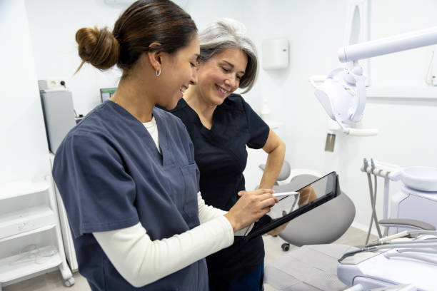 istock Dentist and her assistant looking at a digital tablet in a dental clinic 2198436882
