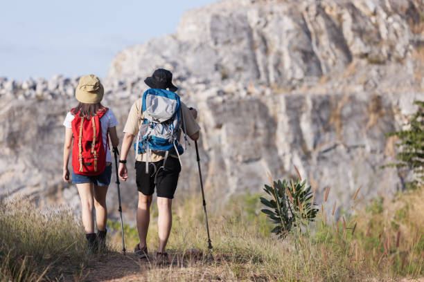 istock A couple hikes along a rugged mountain trail, viewed from behind as they walk side by side 2198444006