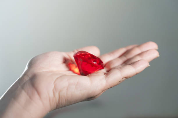 istock Hand Holding Red Ruby Diamond, Precious Gem Crystal on Grey Background, Luxury Jewelry Concept, Luxury Red Gemstone Crystal 2198451775