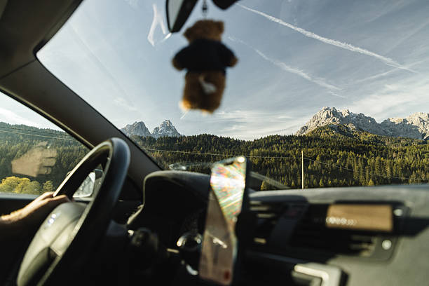 View from camper van driver's seat of woman looking at scenic view of Swiss Alps in autumn