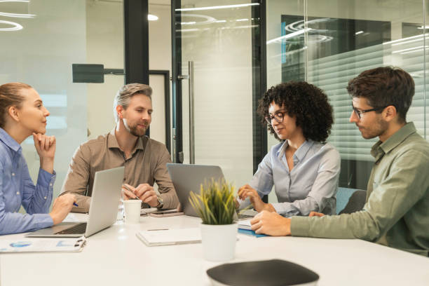 istock Successful businesspeople working in a coworking space working with laptop discussing strategy and business plan in modern office. 2198463416