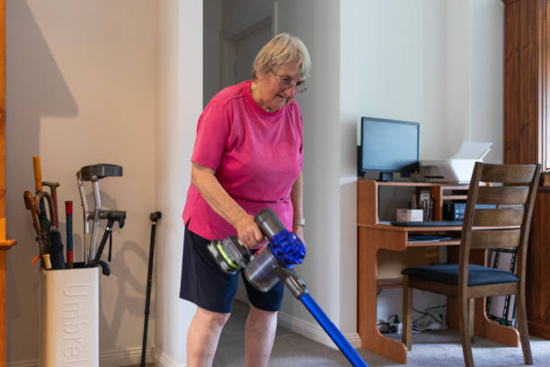 istock Senior woman vacuuming the floor 2198479170