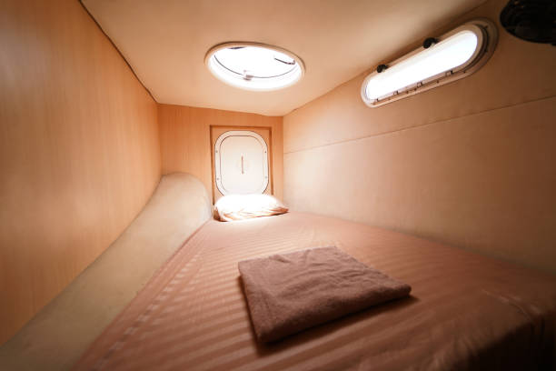 istock Cozy bed on a voyage boat with a window overhead with natural light 2198480078