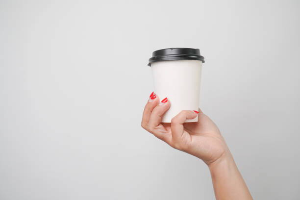 istock Someone hand is holding a paper coffee cup, isolated on white background 2198480423