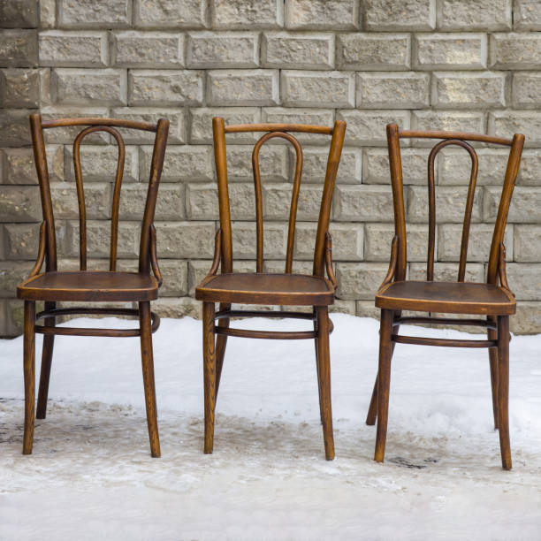 istock Three weathered wooden chairs stand empty in a winter wonderland. 2198483204
