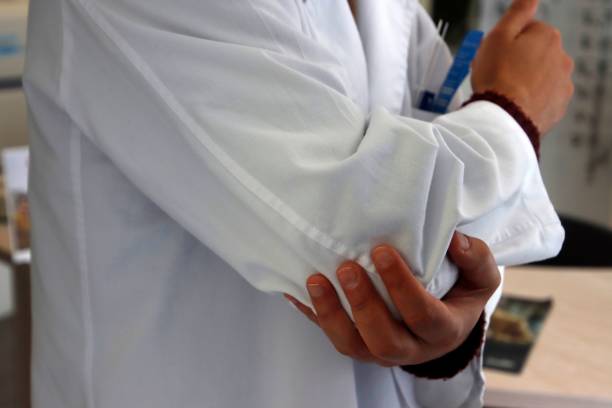 istock Person in lab coat holding elbow 2198485090