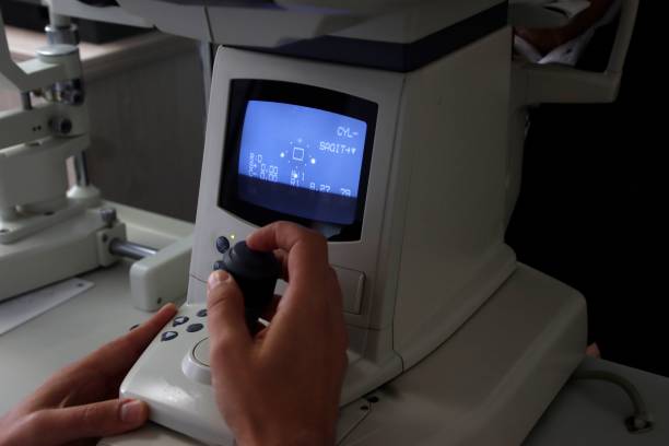 istock Hands operating eye examination machine in clinic. 2198485096