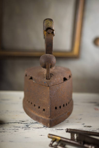 istock Rusty Vintage Iron with Wooden Handle Sitting on a Table 2198486028