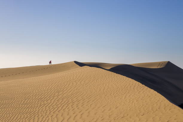 istock Maspalomas Dunes in Gran Canaria. Textured sand dunes with patterns, shadows, and faint footprints. 2198487899