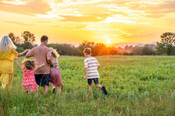 istock Joyful Family Stroll Through Serene Sunset Field 2198489087