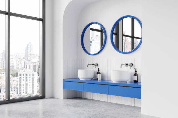 istock Modern bathroom with round mirrors and white sinks on wooden vanity against blue tiled wall. 3D Rendering 2198489609