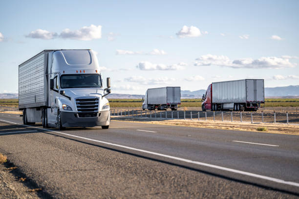 istock White big rig semi truck transporting cargo in refrigerated semi trailer running on the divided highway road with two semi trucks driving in the opposite direction 2198489721