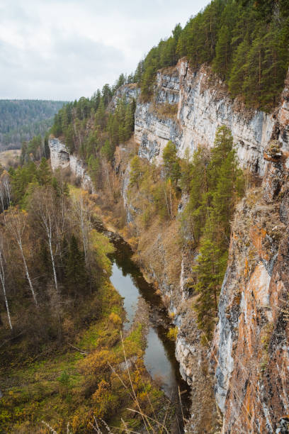 istock Experience a breathtaking autumn landscape characterized by stunning cliffs and a serene river flowing through a lush, vibrant forest 2198491224