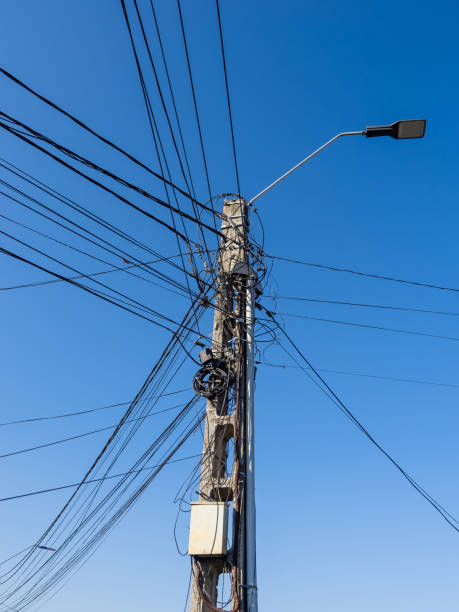 istock Utility Pole and Power Lines Against a Clear Blue Sky 2198494906
