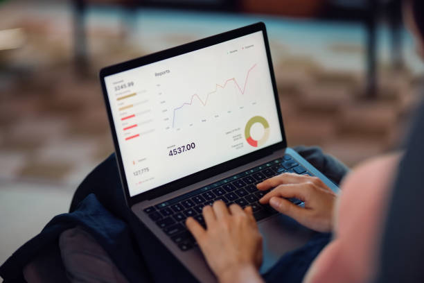 istock Person Analyzing Business Graphs and Reports on a Laptop Screen 2198506507