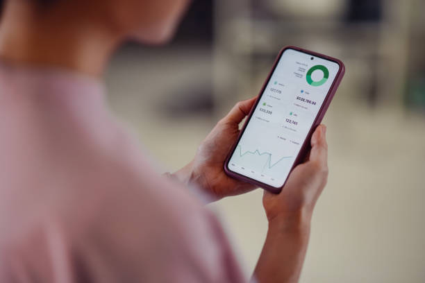 istock Person Holding Smartphone with Financial Application Displayed on Screen 2198506514