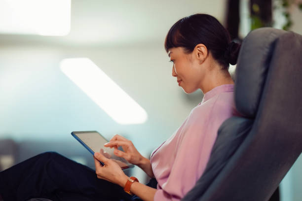 istock Woman Relaxing at Home Using a Tablet Device for Digital Interaction 2198506528