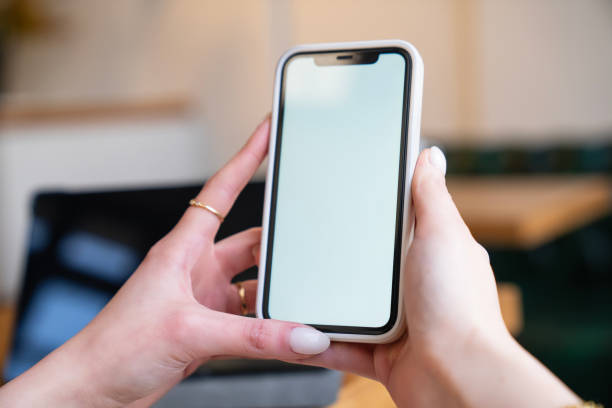 istock Close up or woman using smart phone. Hand holding smartphone with white screen 2198507174