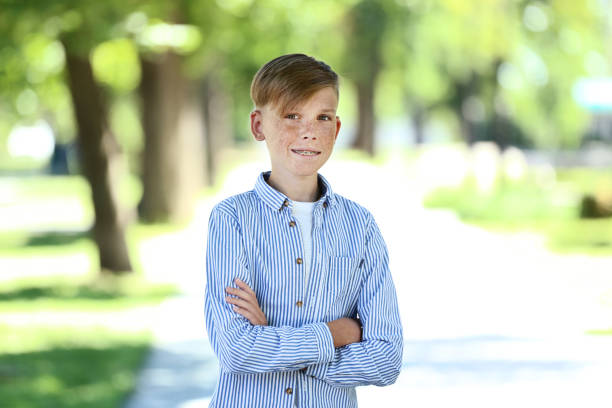 Portrait of an autistic boy in park on a sunny summer day.