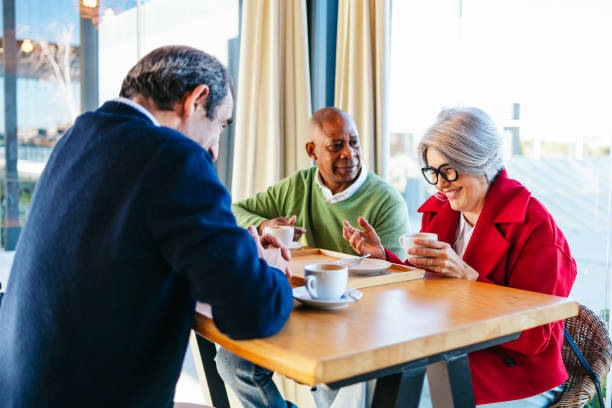 istock Three friends sharing coffee and laughter in a cozy cafe 2198510660