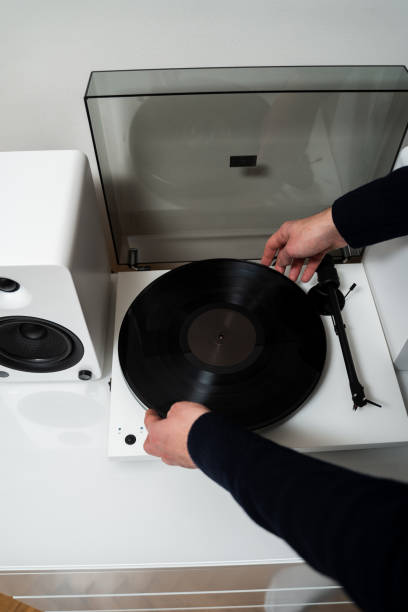 istock Musicians hands adjusting vinyl disc on a needle player close-up. Setting up vinyl speaker system. 2198511864