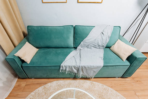istock A stylish mint green couch adorned with a cozy throw blanket and accent pillows, creating a warm atmosphere in a modern living room 2198512377