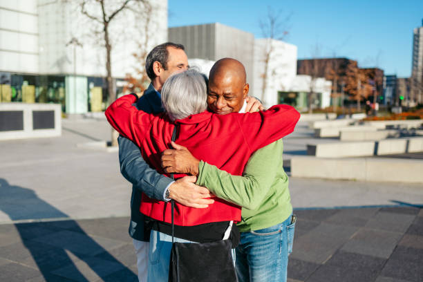 istock Senior friends sharing a warm hug in a city square 2198512815
