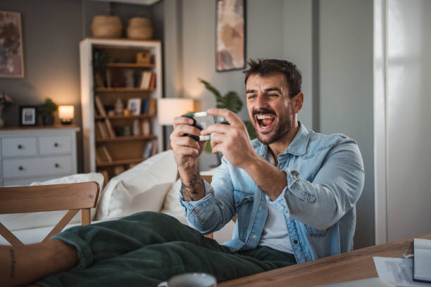 istock Man unwinding with mobile games after a busy workday 2198514805