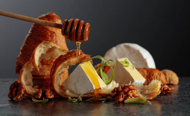istock Camembert cream cheese with honey, croissants, and walnuts. 2198516509