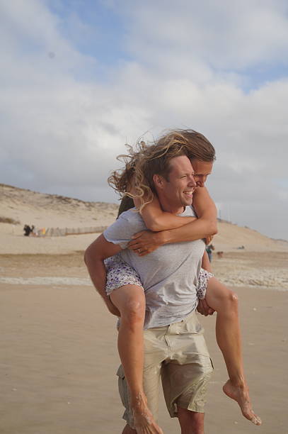 istock Loving couple playing on ocean beach 2198521932