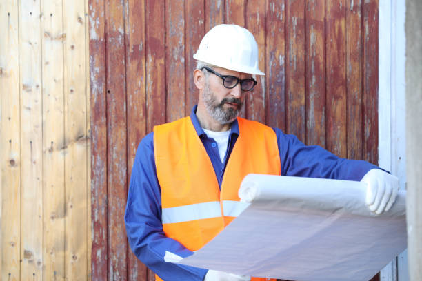 istock Senior Caucasian male architect holding an blueprint, while observing the work on a construction site 2198522116