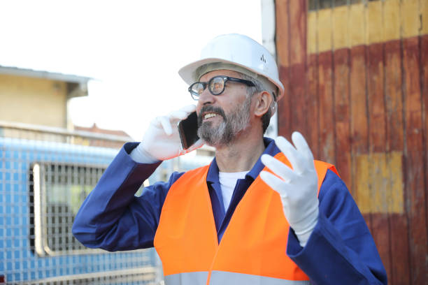 istock Senior worker with helmet on construction site talking with smartphone 2198522955