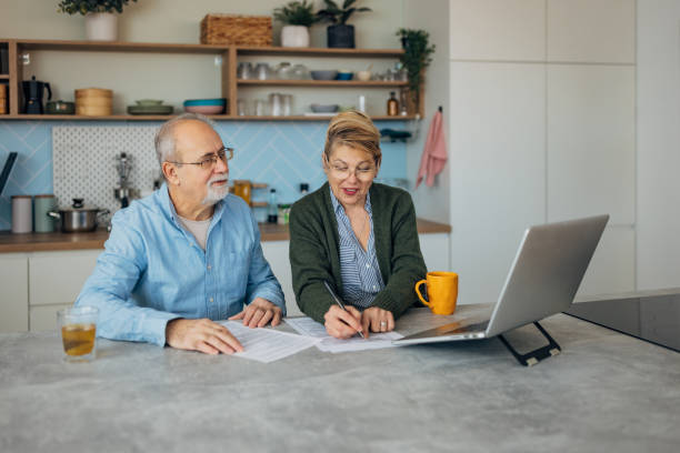 istock A senior couple makes financial plans for retirement with focus and concentration while sitting at the kitchen counter 2198523086