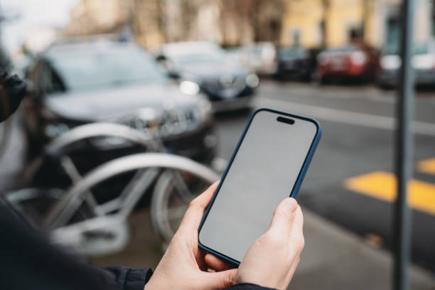istock Woman holding smartphone with blank screen outdoors in urban setting 2198530425