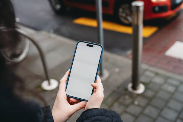 Woman using smartphone with blank white screen outdoors