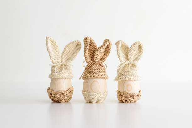 istock Easter decoration with Easter eggs in crochet hats with rabbit ears. Front view 2198541045