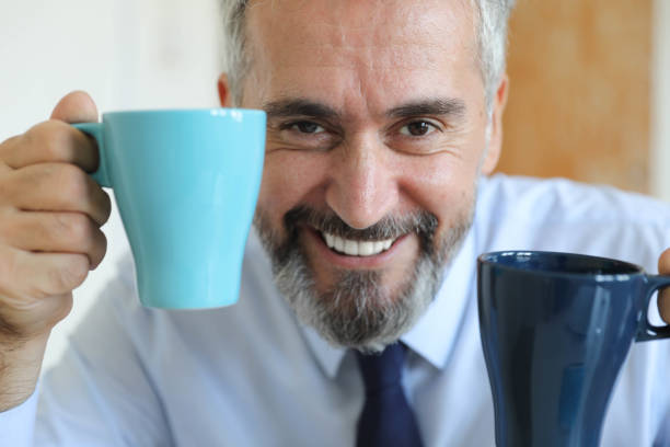 Senior businessman with two coffee cups in his hands