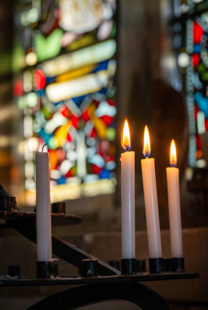 istock Candles in a church with stained glass window 2198544457