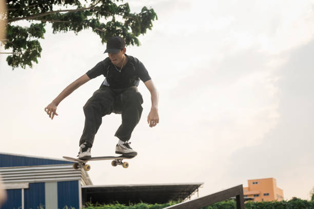 istock Young Skater Jumping Mid-Air During Extreme Skateboarding Stunt 2198548353