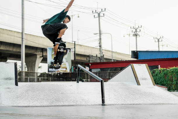A young girl jumping slides her board down a pole at a skatepark