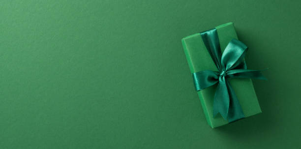 istock Green gift box with a satin ribbon on a matching background, suitable for gift and celebration concepts 2198550711