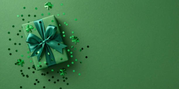 istock Green wrapped gift with a bow surrounded by shamrock and confetti elements, festive theme 2198550712