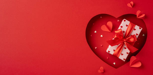 istock Valentine's Day gift box with red ribbon surrounded by heart decorations 2198550725