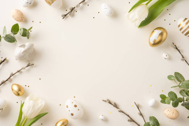 Decorative flat lay arrangement featuring Easter eggs, white tulips, and green foliage on a light background to celebrate the holiday season