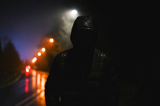 istock Unrecognizable person in hood jacket at night. 2198553392